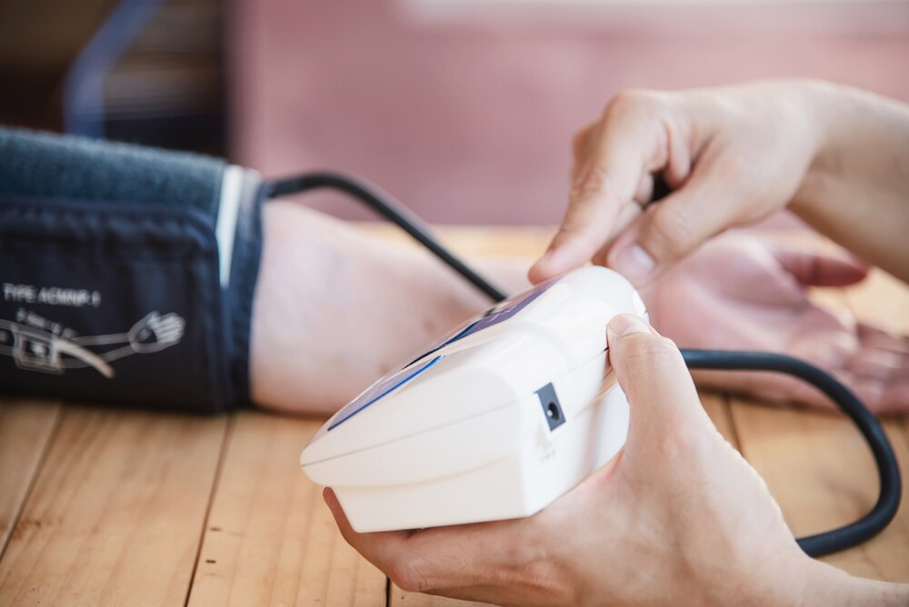 Old lady is being checked blood pressure using blood pressure monitor kid set